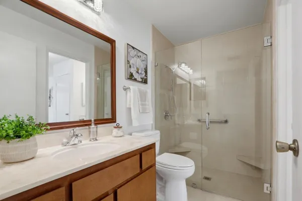 a bathroom with a sink a toilet and shower