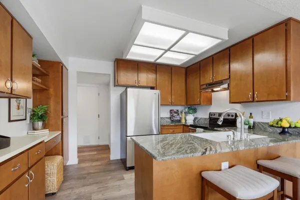 a kitchen with granite countertop lots of counter top space cabinets and stainless steel appliances