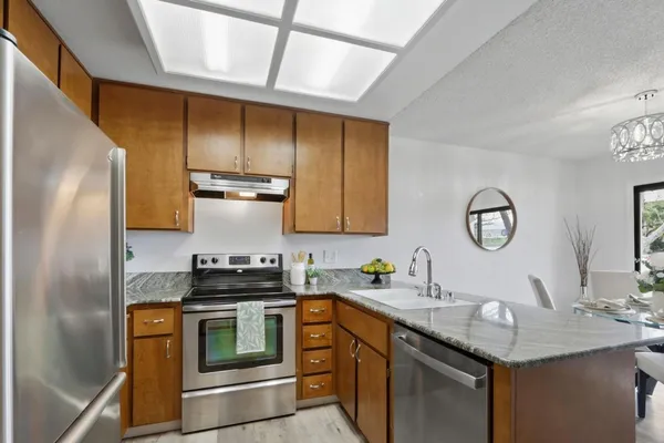 a kitchen with stainless steel appliances granite countertop a sink stove and refrigerator