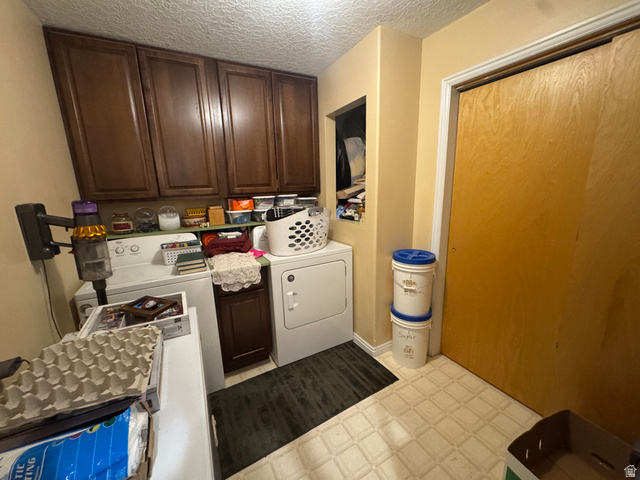 655 North 8th East Preston, ID 83263 - Photo 10 of 32 Laundry room with light floors, cabinet space, a textured ceiling, and washing machine and clothes dryer