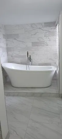 a bathroom with a granite countertop toilet a sink and shower