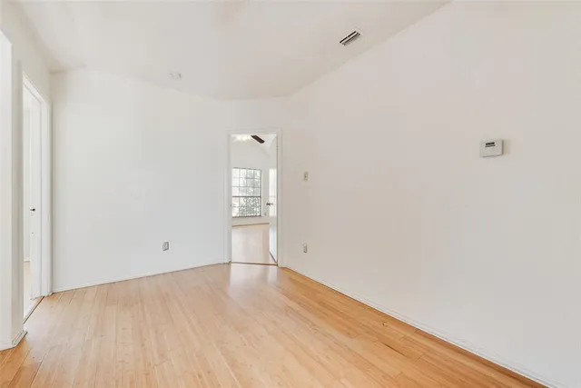 an empty room with windows and ceiling fan