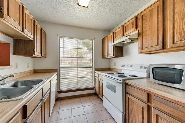 a kitchen with stainless steel appliances granite countertop a sink and a refrigerator