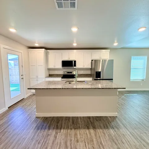 a kitchen with stainless steel appliances a refrigerator sink and microwave