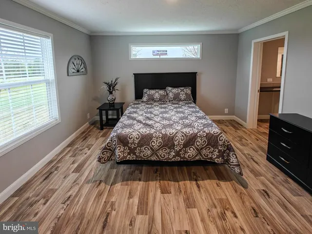 a bedroom with a bed and wooden floor