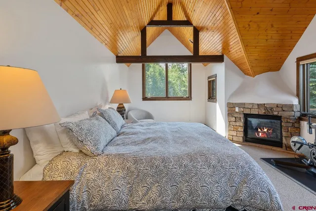 a bedroom with a bed a fireplace and a large window
