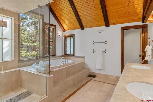 a bathroom with a tub a sink and a large window