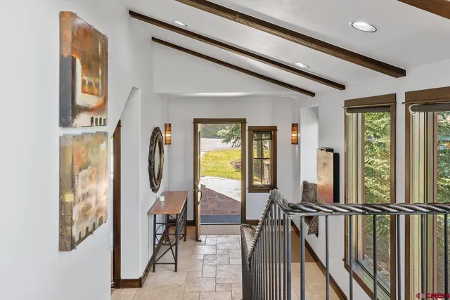 a view of a hallway with wooden floor and windows