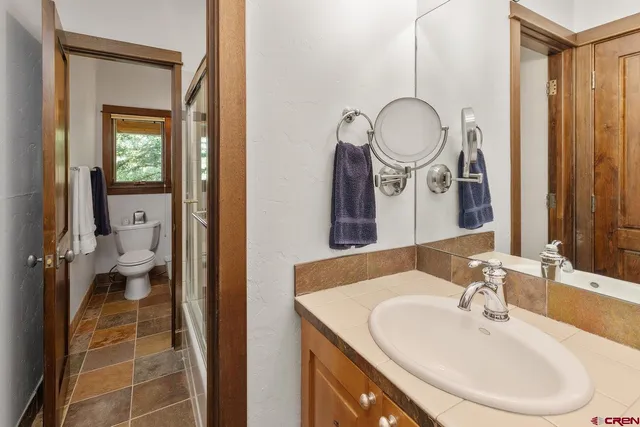 a bathroom with a sink a toilet and a mirror