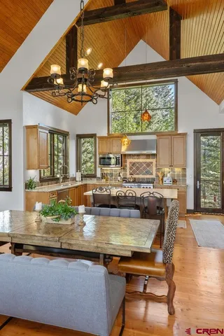 a kitchen with a table chairs stove and wooden floor