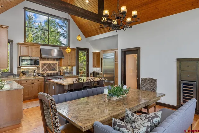 a dining room with furniture a large window and wooden floor