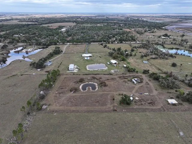 an aerial view of a house with a yard and trees