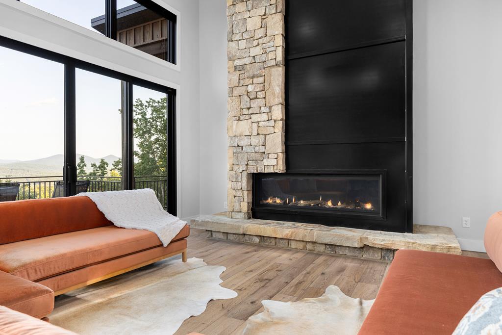 417 Bill Claypool Drive Blue Ridge, GA 30513 - Photo 5 of 73 a living room with furniture a fireplace and a floor to ceiling window