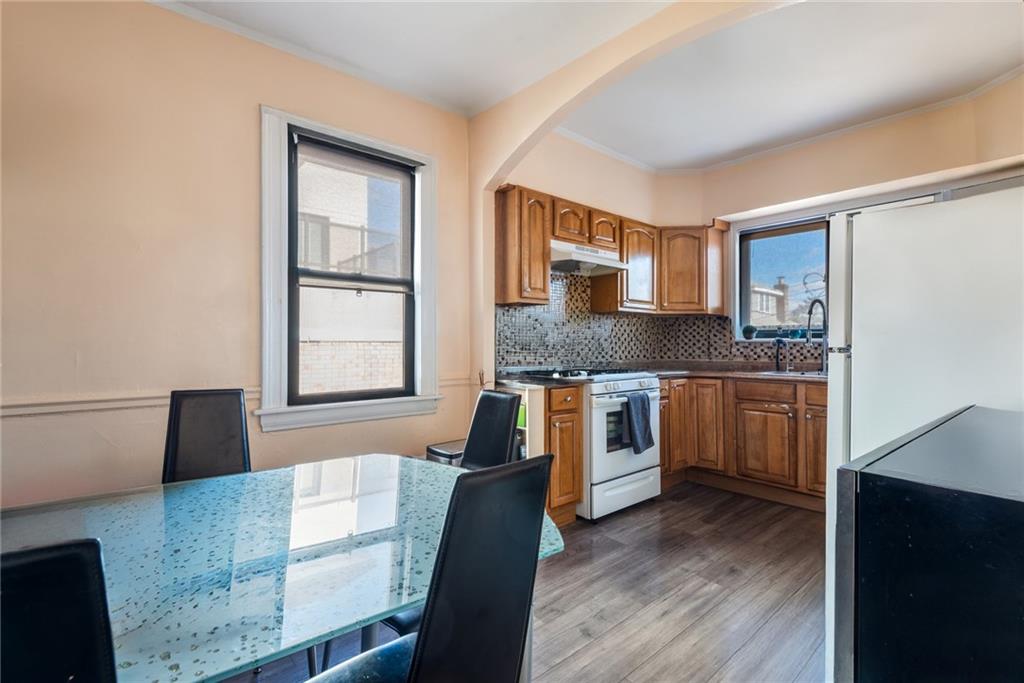 159 Hastings Street Brooklyn, NY 11235 - Photo 31 of 32 a kitchen with granite countertop wooden floors and white appliances