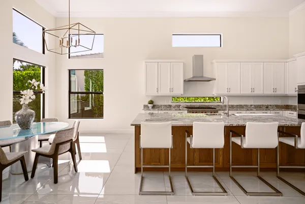 a kitchen with a dining table chairs and white appliances
