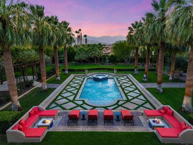a view of a lush green field with mountains in the background
