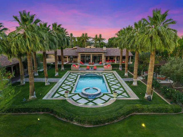 a view of a swimming pool with a lawn chairs under an umbrella