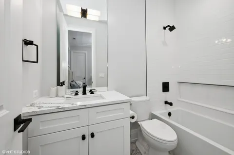a bathroom with a granite countertop toilet a sink and a mirror