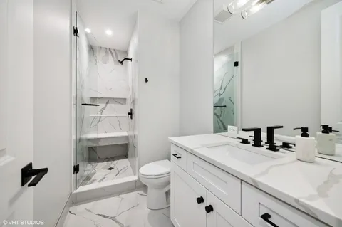 a bathroom with a sink a toilet and shower