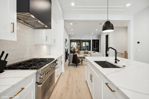 a kitchen with kitchen island stainless steel appliances a stove and a wooden floor