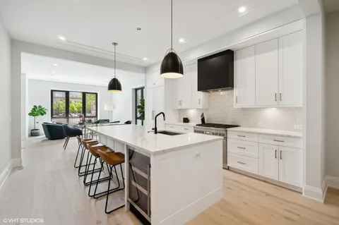 a kitchen with stainless steel appliances a stove a sink island and a refrigerator