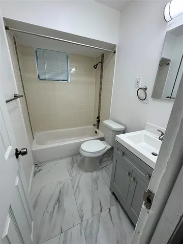 a bathroom with a granite countertop toilet a sink and a mirror