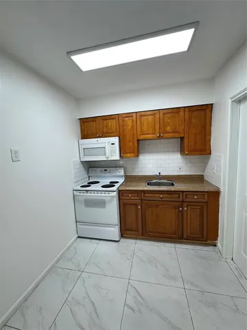 a kitchen with a stove top oven and cabinets