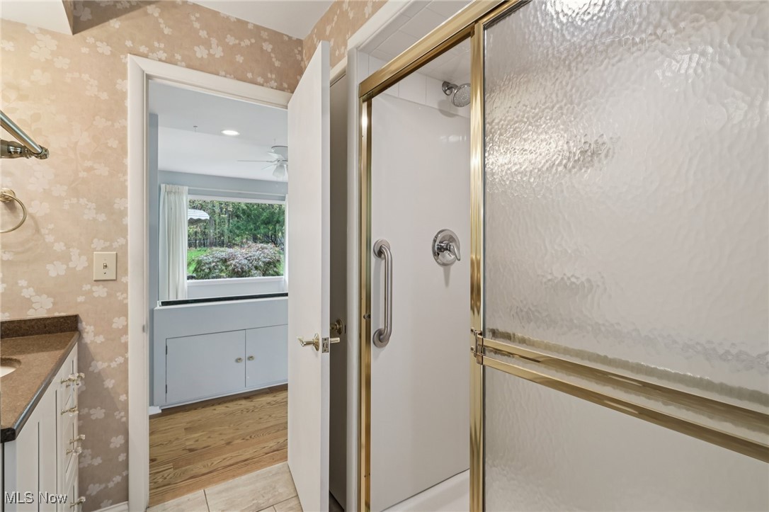 33300 South Woodland Road Cleveland, OH 44124 - Photo 31 of 50 Bathroom featuring wallpapered walls, vanity, a stall shower, and light wood-style floors