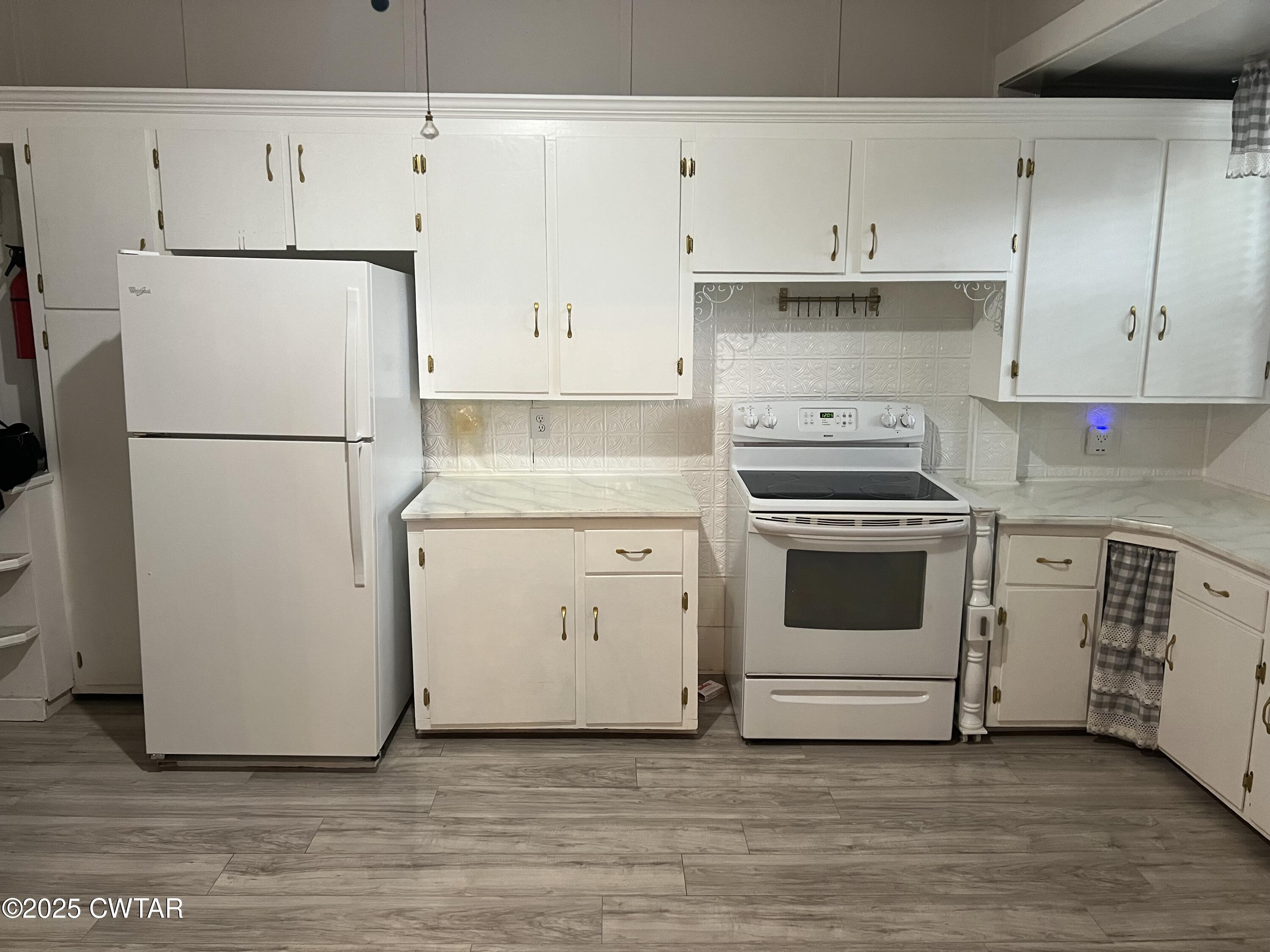 117 South Main Street Gibson, TN 38343 - Photo 18 of 40 a kitchen with cabinets stainless steel appliances and wooden floor