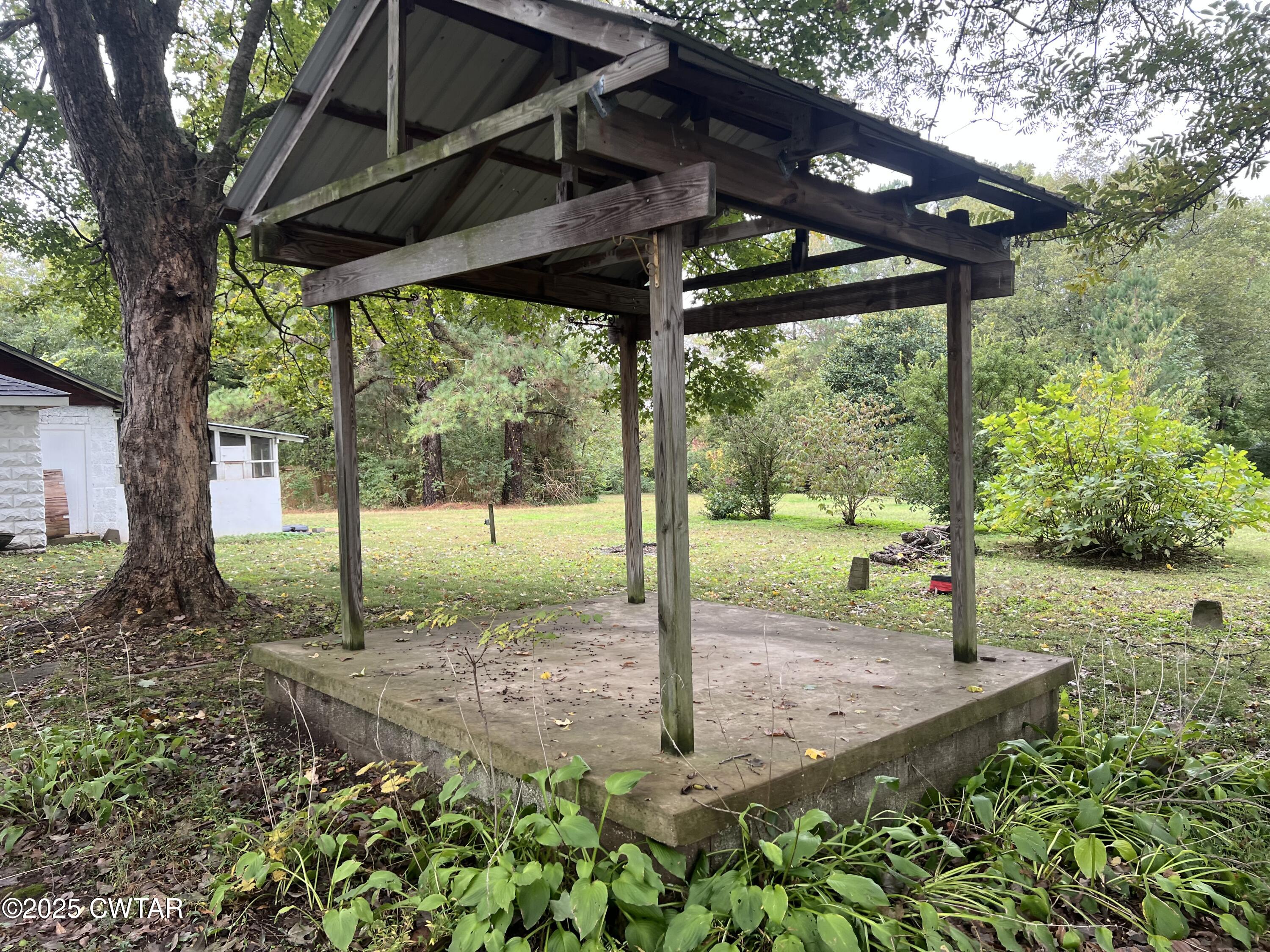117 South Main Street Gibson, TN 38343 - Photo 6 of 40 a view of a backyard with table and chairs under an umbrella