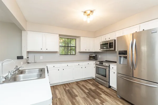 a kitchen with granite countertop a sink stainless steel appliances and counter space