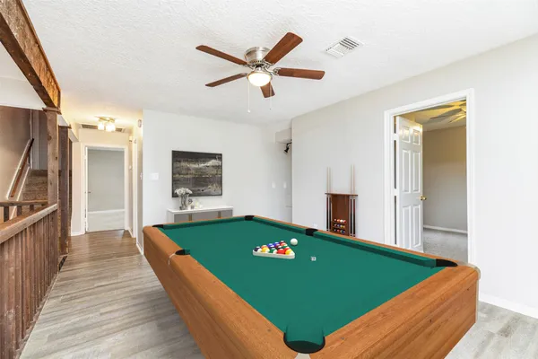 a room with pool table and windows