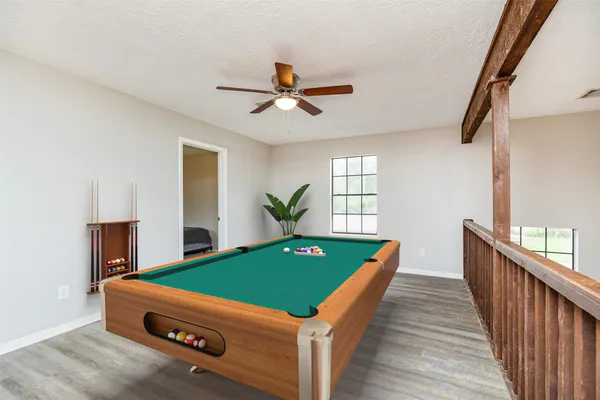 a room with pool table and windows