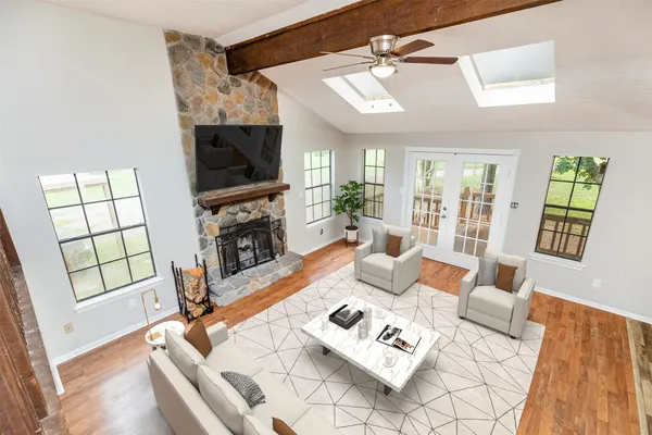 a living room with furniture a flat screen tv and a fireplace