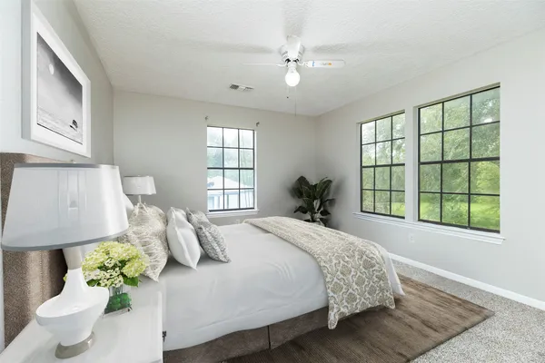 a bedroom with a bed mirror and window