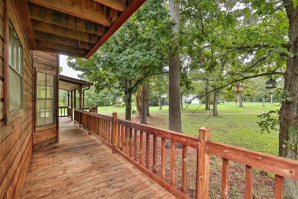 a view of a porch with wooden floor and fence