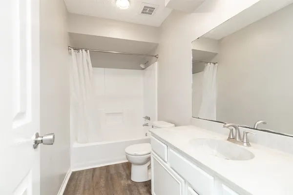 a bathroom with a granite countertop sink toilet a shower and a mirror