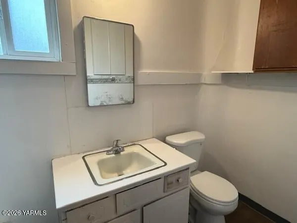 a bathroom with a toilet sink and mirror