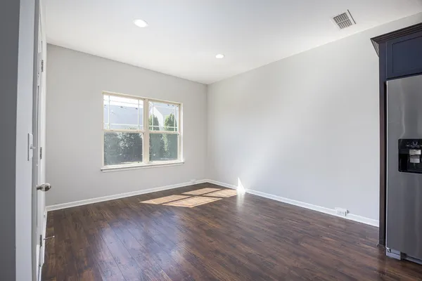 a view of a big room with wooden floor and kitchen