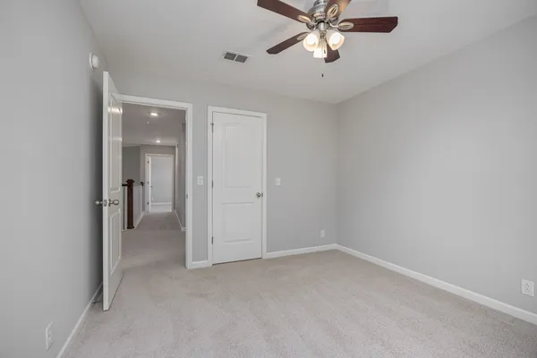 an empty room with a window and ceiling fan