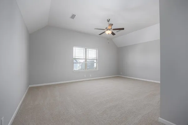 an empty room with a window and a fan