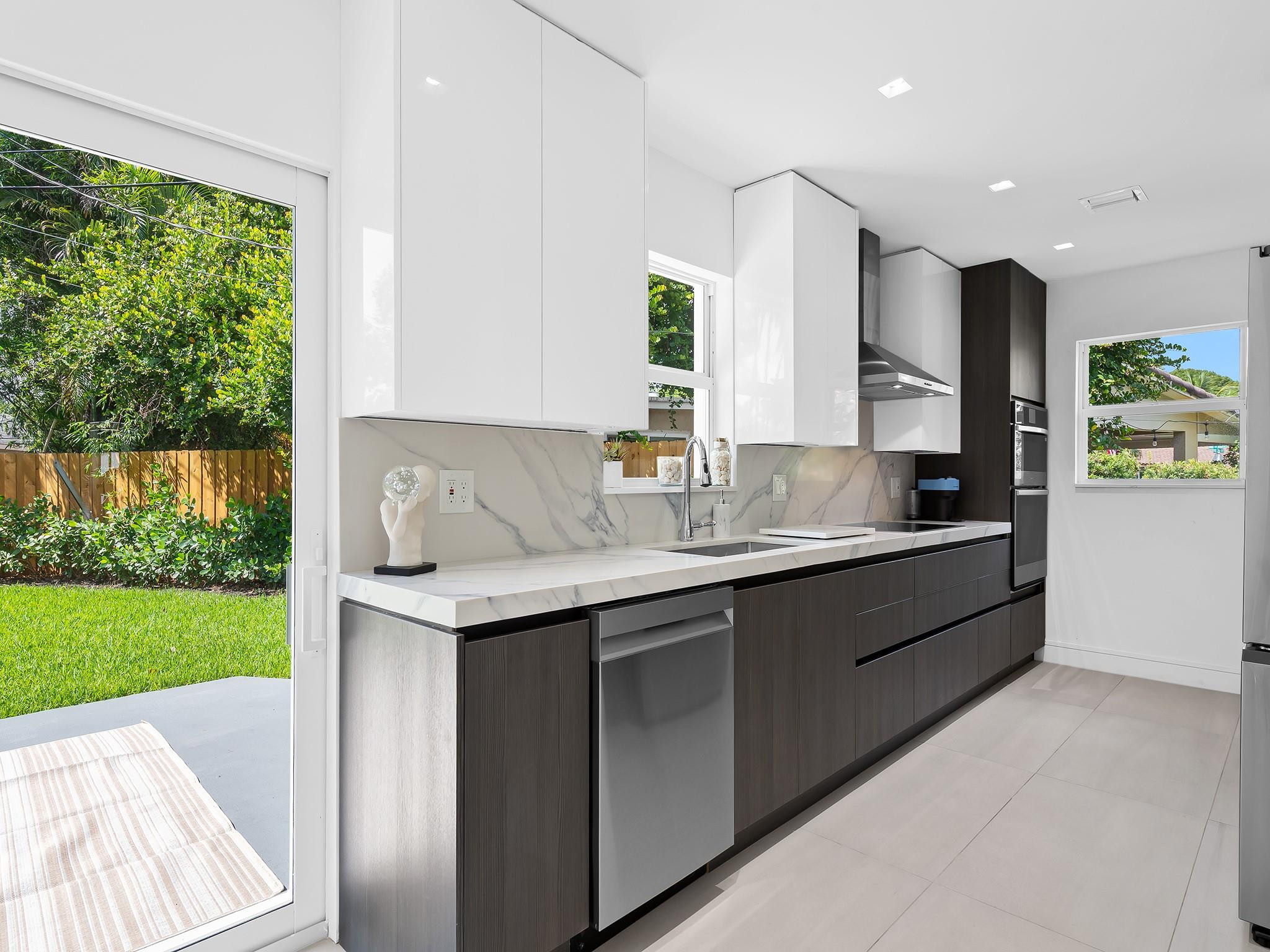 332 Northeast 29th Street Wilton Manors, FL 33334 - Photo 12 of 28 a kitchen with kitchen island granite countertop a sink and a stove top oven