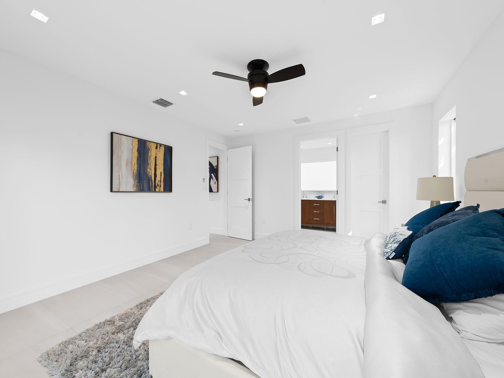 332 Northeast 29th Street Wilton Manors, FL 33334 - Photo 16 of 28 a bedroom with a large bed and a chandelier