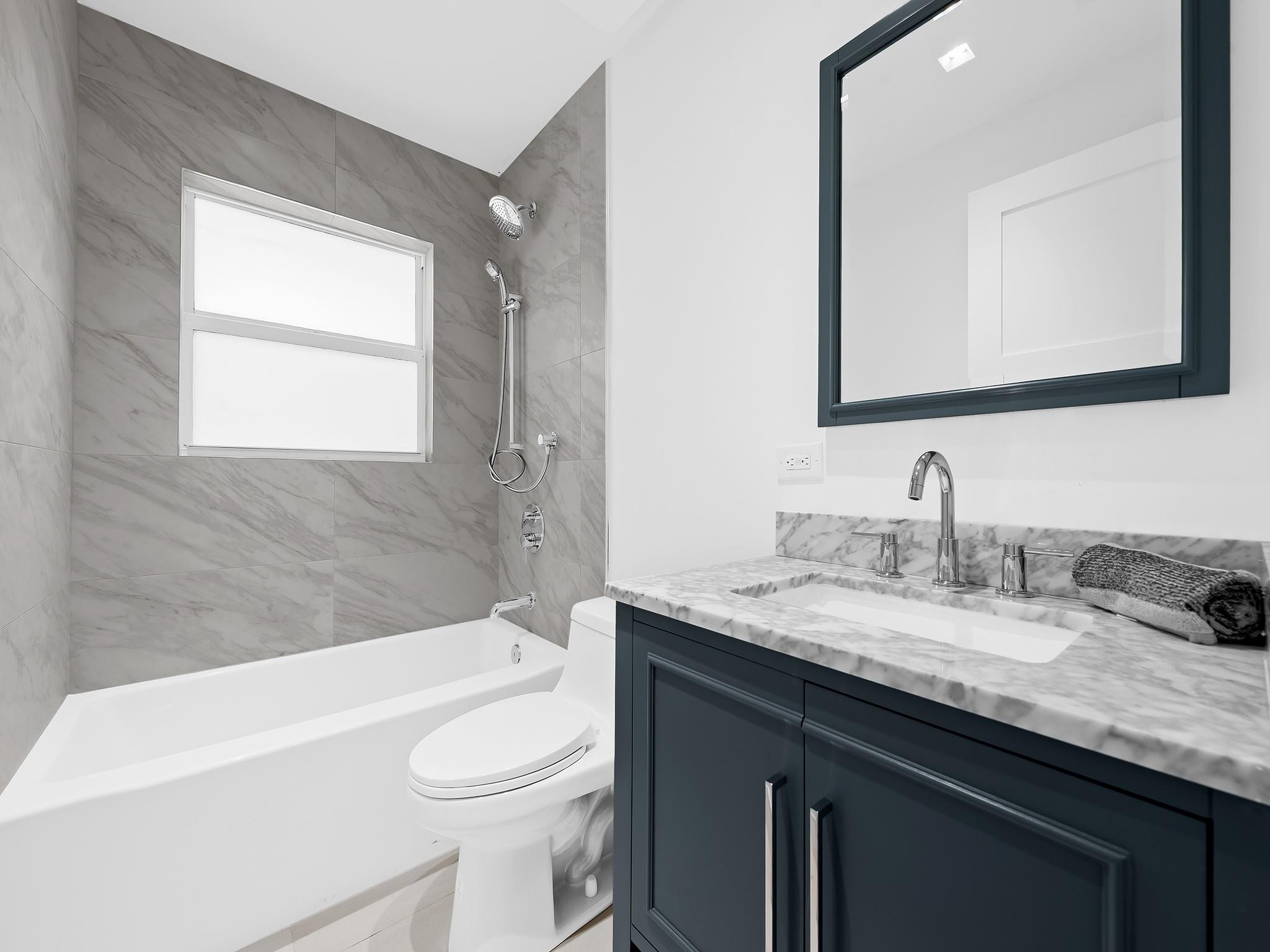 332 Northeast 29th Street Wilton Manors, FL 33334 - Photo 20 of 28 a bathroom with a granite countertop sink mirror vanity and toilet