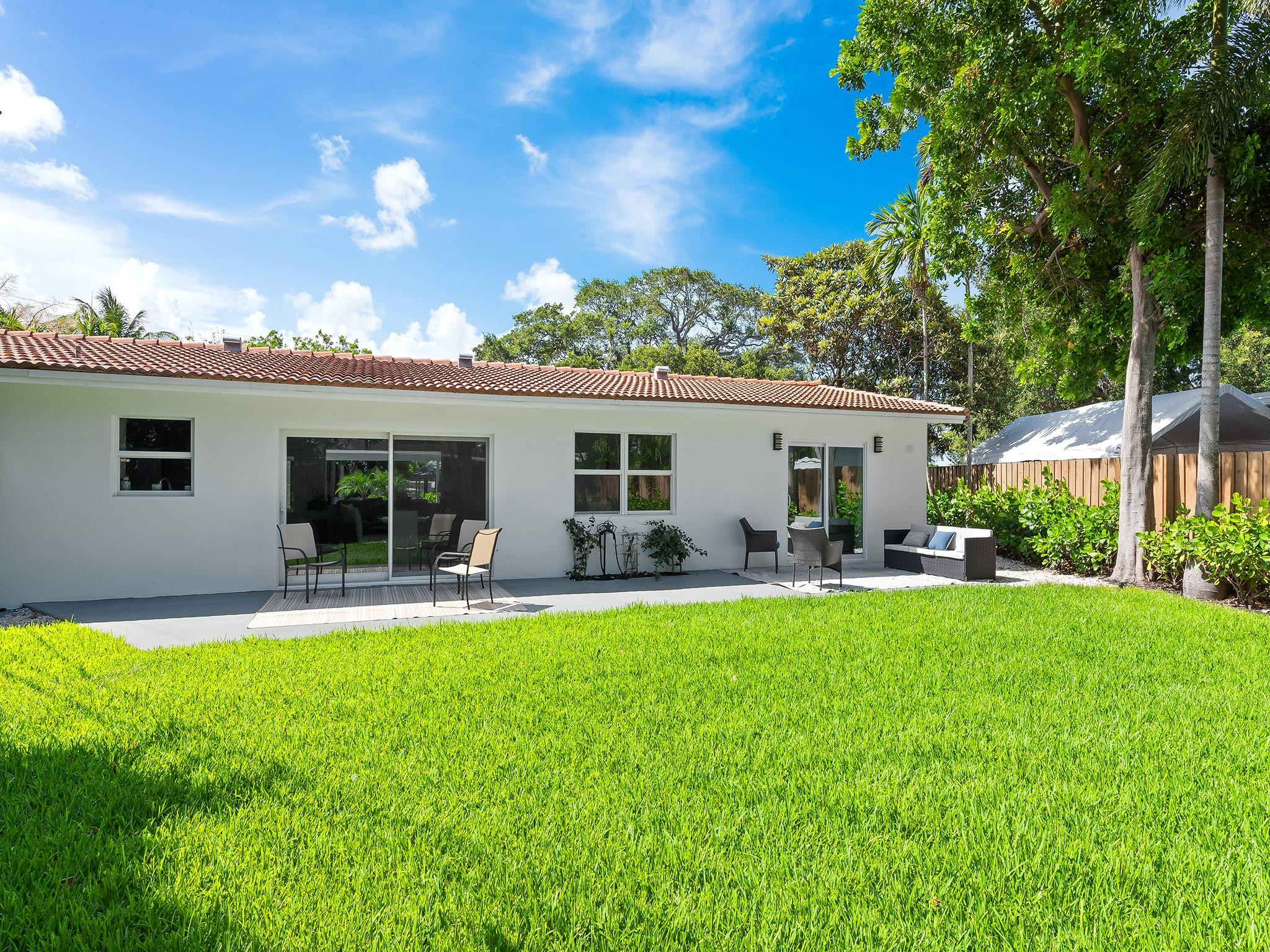332 Northeast 29th Street Wilton Manors, FL 33334 - Photo 23 of 28 a view of a house with a backyard and a patio