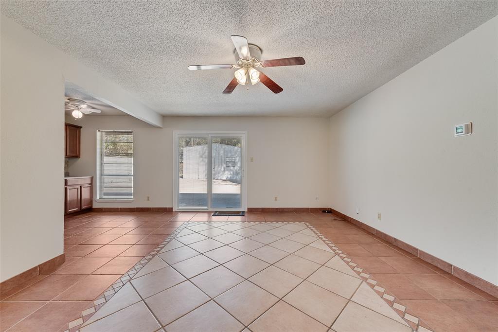 703 Rolling Ridge Lane Duncanville, TX 75116 - Photo 11 of 38 Spare room featuring light tile patterned flooring, inlaid floor details, a textured ceiling, and a ceiling fan