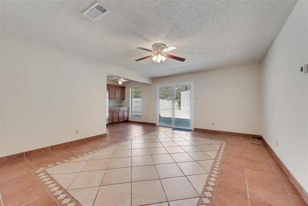 703 Rolling Ridge Lane Duncanville, TX 75116 - Photo 17 of 38 Empty room featuring light tile patterned flooring, a textured ceiling, and a ceiling fan
