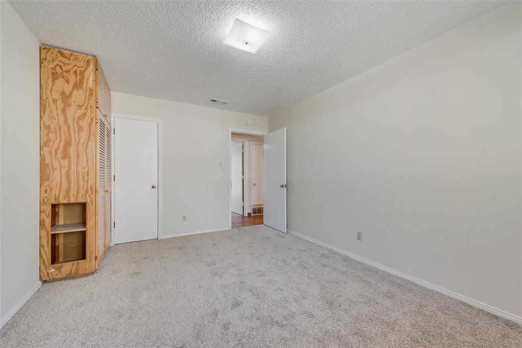 703 Rolling Ridge Lane Duncanville, TX 75116 - Photo 20 of 38 Unfurnished bedroom featuring a textured ceiling and carpet flooring