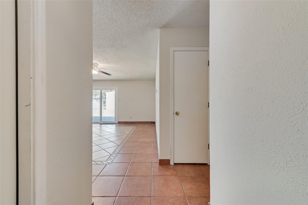 703 Rolling Ridge Lane Duncanville, TX 75116 - Photo 8 of 38 Hall with light tile patterned flooring, a textured ceiling, and a textured wall