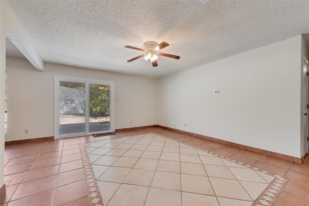 703 Rolling Ridge Lane Duncanville, TX 75116 - Photo 9 of 38 Spare room with light tile patterned floors, a ceiling fan, and a textured ceiling